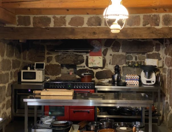 Présentation de la cuisine en pierre apparente : vue sur le piano et le plan de travail